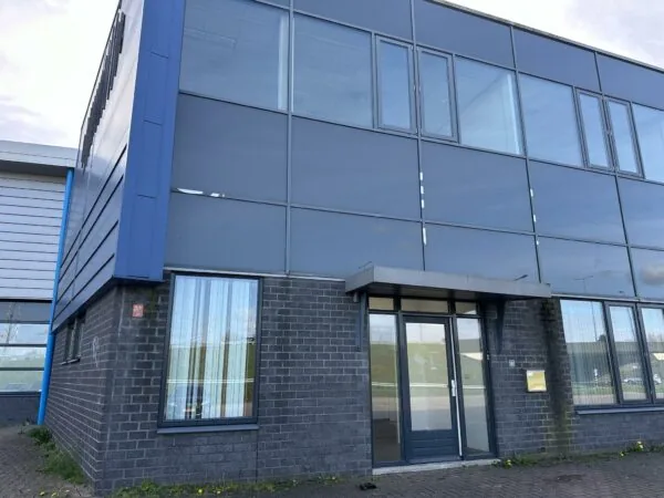 Zakelijk pand aan de Van der Hagenstraat met gevel van donkere bakstenen en grote spiegelende ramen.